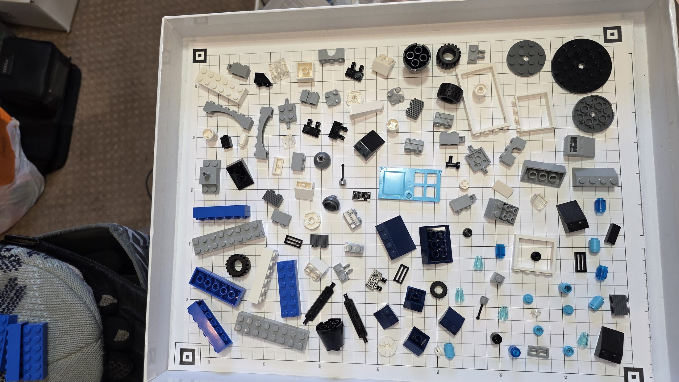 Real tray of brick parts on a calibration sheet