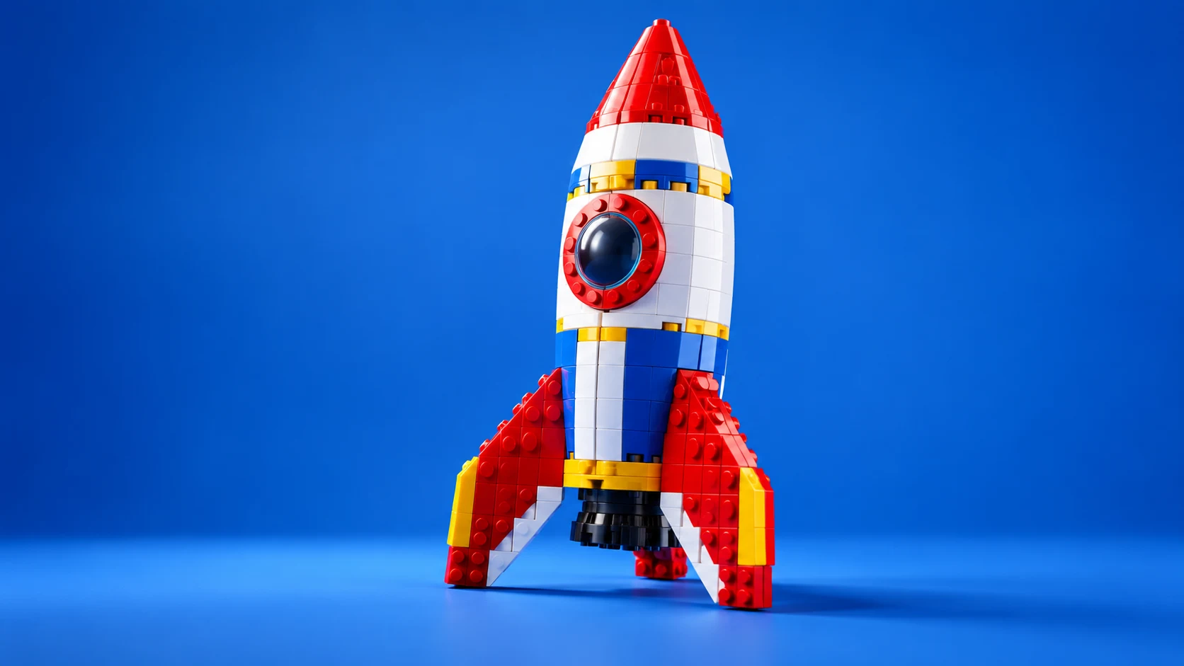 Colorful sculptural brick rocket on a rich blue background